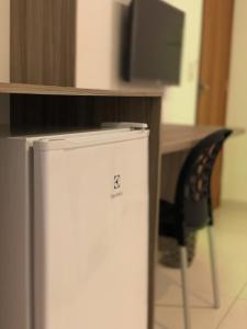 a small refrigerator next to a desk with a television at Pousada Paraíso Maragogi in Maragogi
