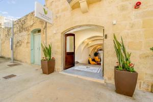 a building with two potted plants in front of a door at Viewpoint Boutique Living in Xlendi
