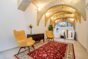 a living room with two chairs and a rug at Viewpoint Boutique Living in Xlendi