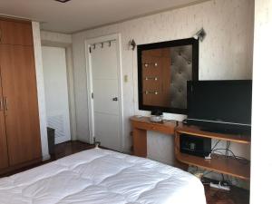 um quarto com uma cama e uma televisão de ecrã plano em 67 sqm. Condo Unit in Robinson Place Residences em Manila
