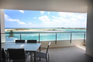 a dining room with a table and a view of the ocean at Monaco Caloundra in Caloundra