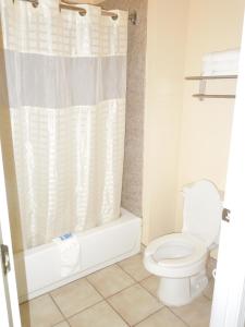 a bathroom with a toilet and a shower at Homegate Inn & Suites West Memphis in West Memphis