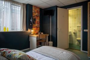 a room with a bed, a toilet and a window at Hotel Villa Flora in Hillegom