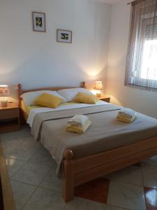 une chambre avec un lit avec deux serviettes dessus dans l'établissement Marina & Luka, à Povljana