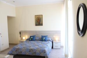 a bedroom with a bed with blue pillows and a mirror at Hotel Luca in Lido di Camaiore