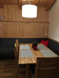 アウフファッハにあるAppartement Mühlhäuslのダイニングルーム(鉢植えの植物のある木製テーブル付)