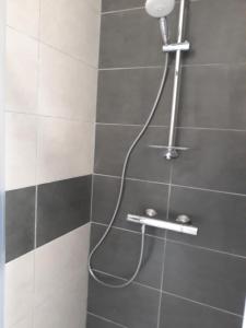 a shower with a hose attached to a wall at Chalet "Les Gobelins" in Paimpont