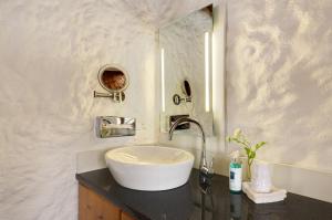 a bathroom with a white sink and a mirror at Landhotel Binderhäusl Garni in Inzell +20 photos