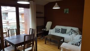 sala de estar con sofá blanco y mesa en El Balcón del Sella, en Cangas de Onís