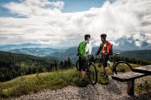 two men standing on a hill with their bikes at Landhotel Binderhäusl in Inzell