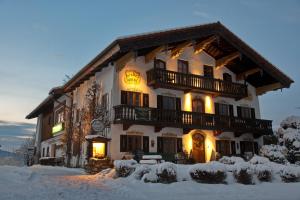 a large building with snow in front of it at Landhotel Binderhäusl Garni in Inzell