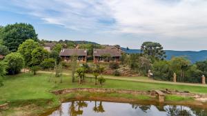 a house on a hill next to a lake at Misty Mountain in Sabie