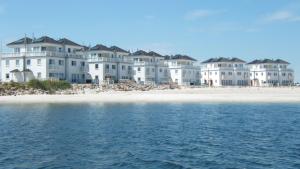 a row of houses on the beach next to the water at Komfort-Ferienwohnung Dat Penthuus by Meer-Ferienwohnungen in Olpenitz