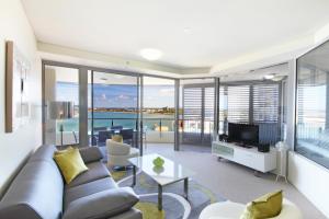 a living room filled with furniture and a large window at Monaco Caloundra in Caloundra