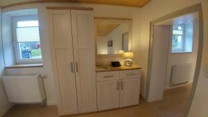 a kitchen with white cabinets and a window at Moderne Ferienwohnungen am Kurpark - zentral, ruhig & nah am Edersee in Bad Wildungen