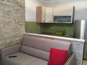 un divano con un cuscino rosso in cucina di Apartmani Marica a Kustići