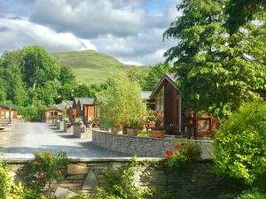 una fila de cabañas en un pueblo con flores en Otter Lodge Auchterarder, en Auchterarder