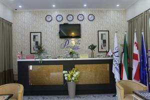 a lobby with a reception desk with clocks on the wall at Paradise Investment Resort in Tʼelavi