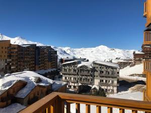 een balkon met uitzicht op een stad met besneeuwde bergen bij La Roche Blanche in Val Thorens