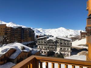 einen Balkon mit Blick auf eine Stadt mit schneebedeckten Bergen in der Unterkunft La Roche Blanche in Val Thorens