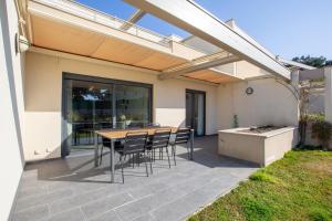 eine Terrasse mit einem Tisch und Stühlen unter Markise in der Unterkunft T2 au coeur de Porticcio - Vue mer Imprenable ! in Grosseto-Prugna