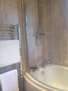uma casa de banho com um chuveiro e uma banheira em Otter Lodge Auchterarder em Auchterarder