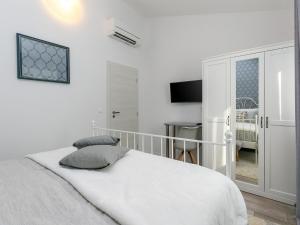 a white bedroom with a bed and a table at Holiday Dream in Vrsar
