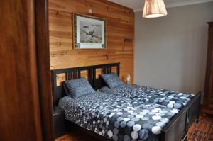a bedroom with a bed with a wooden wall at Santa Fe - Lutrebois in Bastogne