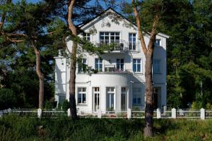 una casa blanca con árboles delante de ella en Villa Desny, en Bansin
