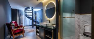 a bathroom with a sink and a spiral staircase at Moon and Chalice Boutique Hotel in Kunming
