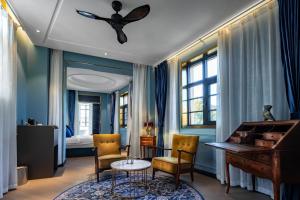 a room with a piano and two chairs and a table at Moon and Chalice Boutique Hotel in Kunming