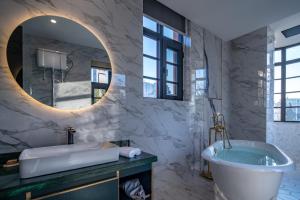 a bathroom with a tub and a large mirror at Moon and Chalice Boutique Hotel in Kunming