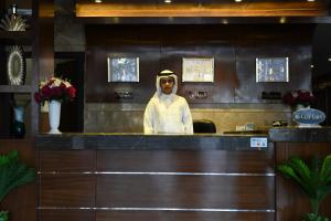 un hombre parado detrás de un mostrador en un restaurante en Hudo Al Masa Apartment Hotel en Riad