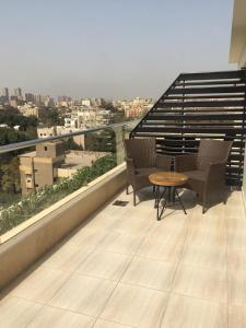 een balkon met 2 stoelen en een tafel op een gebouw bij Royal Maadi Hotel in Caïro