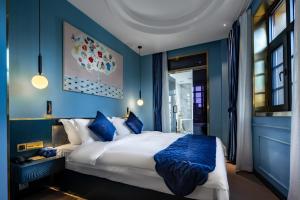 a blue bedroom with a large bed with blue walls at Moon and Chalice Boutique Hotel in Kunming