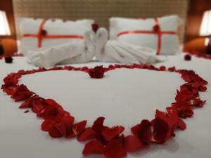 un gâteau en forme de cœur avec des roses rouges sur une table dans l'établissement ماسة داركم للوحدات السكنية, à Buraydah