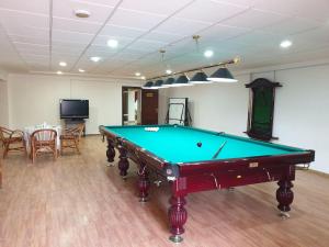 a pool table in a room with a table and chairs at GRAND STAR HOTEL in Qarshi