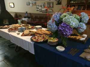 una mesa con comida y flores encima en Kaapsche Hoop Gastehuis, en Kaapsehoop