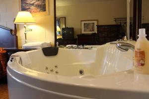 eine weiße Badewanne mit einem Wasserhahn im Bad in der Unterkunft Ritz Inn Niagara in Niagara Falls