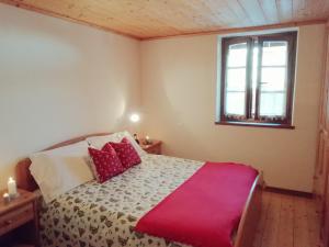 ein Schlafzimmer mit einem Bett mit einer roten Decke darauf in der Unterkunft Albergo Riglarhaus in Sauris