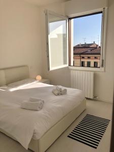 1 dormitorio con cama blanca y ventana grande en Appartamento SAN MICHELE, en Verona