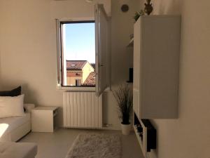 sala de estar con sofá blanco y ventana en Appartamento SAN MICHELE, en Verona