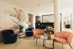 a lobby with chairs and tables and a piano at Residence Hotel in Vaduz