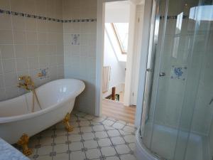 een badkamer met een bad en een douche bij Villa Buiten 53 in Callantsoog +25 foto's