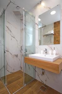 a bathroom with a sink and a shower at Elena Apartment&Spa in Zlatibor
