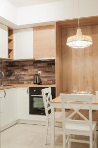 uma cozinha com uma mesa e cadeiras brancas e um candelabro em Brown Sugar | free garage | 2 separate rooms na Cracóvia