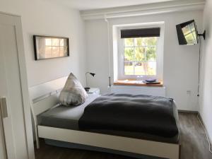 a bedroom with a bed and a window at Pension Schackstedt in Schackstedt