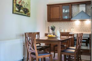 a kitchen with a wooden dining room table and chairs at VILLA MARITINA in Kefallonia