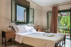 a bedroom with a large bed and a balcony at VILLA MARITINA in Kefallonia