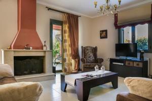 a living room with a fireplace and a coffee table at VILLA MARITINA in Kefallonia